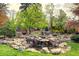 Serene backyard features a tranquil koi pond, a picturesque waterfall, and landscaped surroundings at 6402 E Cornell Ave, Denver, CO 80222