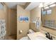 Functional bathroom with neutral tones featuring a shower and vanity with solid surface top at 6402 E Cornell Ave, Denver, CO 80222