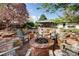 Backyard fire pit features chairs and is set amongst mature trees and beautiful landscaping at 6402 E Cornell Ave, Denver, CO 80222