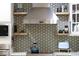 Stainless steel range hood in kitchen with accent tile and open wood shelves at 6402 E Cornell Ave, Denver, CO 80222