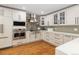 This kitchen has white cabinets, marble countertops, stainless steel appliances and wood floors at 6402 E Cornell Ave, Denver, CO 80222
