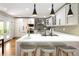 Kitchen island with white countertop and seating for three, overlooking modern kitchen features at 6402 E Cornell Ave, Denver, CO 80222