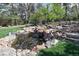 Lush backyard with a gorgeous koi pond and waterfall surrounded by mature trees and landscaping at 6402 E Cornell Ave, Denver, CO 80222
