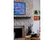 Living room with stone fireplace with hearth, a mounted TV and art on the walls at 6402 E Cornell Ave, Denver, CO 80222