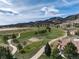 Beautiful aerial view of a golf course with a lake, surrounded by mature trees and homes, blending recreation and residence at 16226 River Haven Way, Morrison, CO 80465