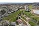 Expansive aerial view of homes and a golf course community with a lake, showcasing a neighborhood's layout and amenities at 16226 River Haven Way, Morrison, CO 80465