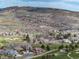 Scenic aerial view of homes and golf course nestled against rocky hills, offering a serene community setting at 16226 River Haven Way, Morrison, CO 80465