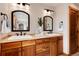 Bathroom featuring a double vanity with wooden cabinets and large mirrors at 16226 River Haven Way, Morrison, CO 80465