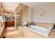 Luxurious bathroom showcasing a soaking tub, walk-in shower, and wooden vanity at 16226 River Haven Way, Morrison, CO 80465