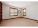 Bright room with neutral carpet, two windows and wood trim at 16226 River Haven Way, Morrison, CO 80465