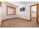 Bedroom with neutral carpet, wood trim, a TV and an entrance to a walk in closet at 16226 River Haven Way, Morrison, CO 80465