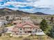 Sprawling two-story home with a stone and stucco exterior, complemented by a lush, landscaped yard and mountain views at 16226 River Haven Way, Morrison, CO 80465