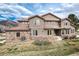 Stately home showcasing a mix of stucco and stone exterior, complemented by a well-maintained lawn and mountain backdrop at 16226 River Haven Way, Morrison, CO 80465