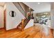 Elegant foyer with hardwood floors, a staircase with iron railings, and a view into a bright, open living space at 16226 River Haven Way, Morrison, CO 80465