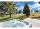Outdoor hot tub with a view of the lush, green, landscaped backyard and mature trees at 16226 River Haven Way, Morrison, CO 80465