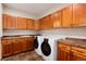 Well-equipped laundry room features wood cabinets, granite counters, washer and dryer at 16226 River Haven Way, Morrison, CO 80465