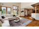 Open concept living area boasts hardwood floors, a large sectional, and views to the home's entry at 16226 River Haven Way, Morrison, CO 80465