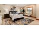 A spacious main bedroom features neutral decor and a window with backyard views at 16226 River Haven Way, Morrison, CO 80465