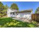 Exterior of two-story home and fenced yard with grassy area at 7542 Otis St, Arvada, CO 80003