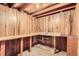 Unfinished basement with wooden paneled walls and utility sink at 7542 Otis St, Arvada, CO 80003