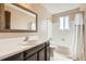 Neutral bathroom with a white tile bathtub and an oval sink at 7542 Otis St, Arvada, CO 80003