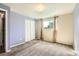 Bedroom featuring carpet, window, closet, and door at 7542 Otis St, Arvada, CO 80003
