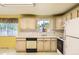 Eat-in kitchen featuring white appliances, tile backsplash, light wood cabinets and window view at 7542 Otis St, Arvada, CO 80003