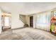 Living room features a staircase, front door, large window, and vintage jukebox at 7542 Otis St, Arvada, CO 80003