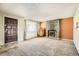 Living room featuring rock fireplace, vintage juke box, carpeted floor, and front door at 7542 Otis St, Arvada, CO 80003