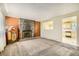 Carpeted living room with rock fireplace, open view to kitchen and vintage jukebox at 7542 Otis St, Arvada, CO 80003