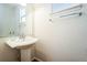 Bright half bathroom featuring a pedestal sink, large mirror and chrome towel bar at 2983 Fulton St, Denver, CO 80238