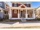Classic red two-story home featuring a covered front porch with traditional columns at 2983 Fulton St, Denver, CO 80238
