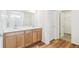 Bathroom boasts a double sink vanity, wood-look floors, and a walk-in shower at 13402 E 110Th Way, Commerce City, CO 80022