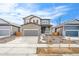 Attractive two-story home with stone accents, a gray garage door, and professional landscaping at 13402 E 110Th Way, Commerce City, CO 80022