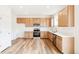 Bright kitchen showcasing stainless steel appliances, wood cabinets, white countertops, and hardwood floors at 13402 E 110Th Way, Commerce City, CO 80022