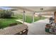 A covered patio featuring an outdoor table with a green yard and a hillside at 12101 Riverdale Rd, Brighton, CO 80602
