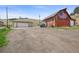 Spacious red barn with an American flag and a detached garage on a large lot with a gravel driveway at 12101 Riverdale Rd, Brighton, CO 80602