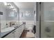 Bathroom with double sinks, tile flooring, and a shower featuring a glass door at 12101 Riverdale Rd, Brighton, CO 80602