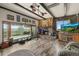 Inviting living room with wood beams, rock fireplace, and expansive windows providing scenic views at 12101 Riverdale Rd, Brighton, CO 80602