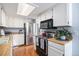 Bright kitchen with stainless steel appliances, white cabinets, and hardwood floors at 60 S Moline St, Aurora, CO 80012