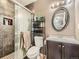 Modern bathroom features a glass-enclosed shower, dark vanity, and updated fixtures at 12682 Kearney St, Thornton, CO 80602