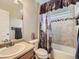 Bathroom with a shower-tub combo, decorative tile accents, and a nature-themed shower curtain at 12682 Kearney St, Thornton, CO 80602