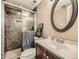 Well-maintained bathroom featuring a tiled walk-in shower, modern fixtures, and a stylish round mirror at 12682 Kearney St, Thornton, CO 80602