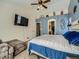 Cozy bedroom featuring a ceiling fan, wall-mounted TV, and a convenient en-suite bathroom at 12682 Kearney St, Thornton, CO 80602