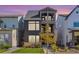 Three-story modern home with gray siding, stone accents, and a landscaped yard at 16722 Shoshone St, Broomfield, CO 80023