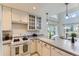 Bright kitchen features white cabinets, granite countertops, a gas range and stainless steel dishwasher at 19440 E Mann Creek Dr # E, Parker, CO 80134