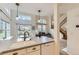 Bright and airy kitchen with granite counters, double sink, and open view to the living room and stairway at 19440 E Mann Creek Dr # E, Parker, CO 80134