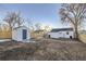 Backyard view with shed, wooden fence, and a partially visible home at 1840 S Shoshone St, Denver, CO 80223