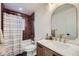 Modern bathroom with dark red tile, updated vanity, and a bathtub at 1840 S Shoshone St, Denver, CO 80223