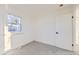 Simple bedroom with grey carpet, white walls, and a window with natural light at 1840 S Shoshone St, Denver, CO 80223